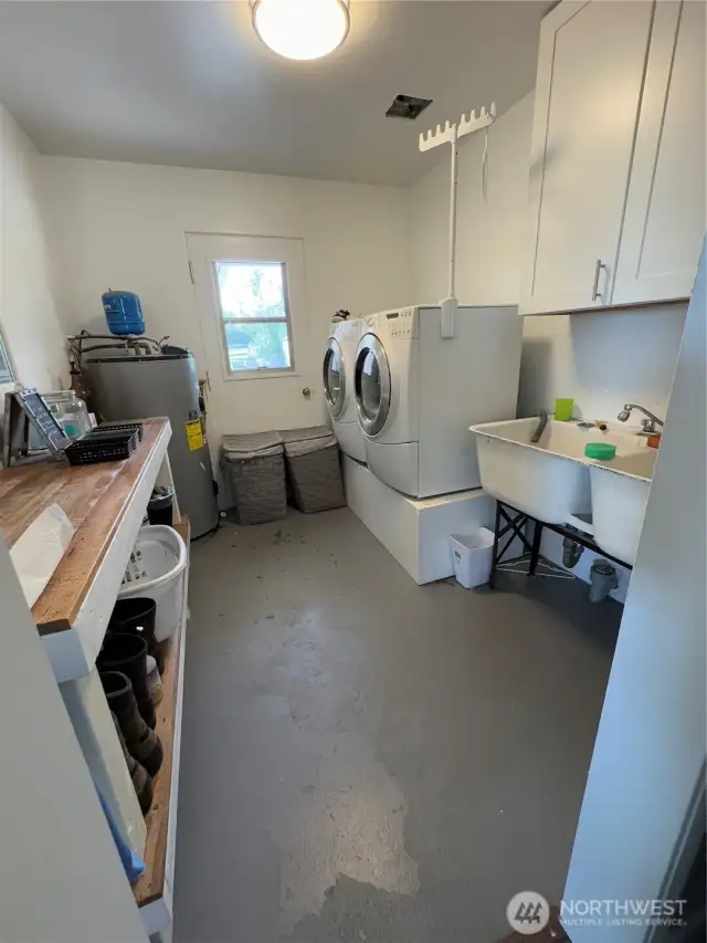 Utility room with utility sink and hot water tank... also door to back patio...