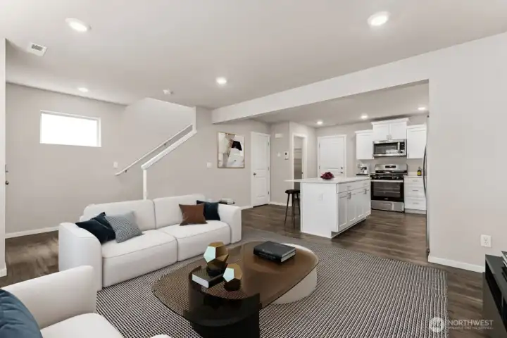Open sightlines from living area to kitchen keep everyone connected, with durable plank flooring underfoot. Pictures are for representational purposes only, colors and features may vary.
