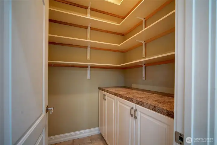 Spacious pantry with shelving and cabinets.