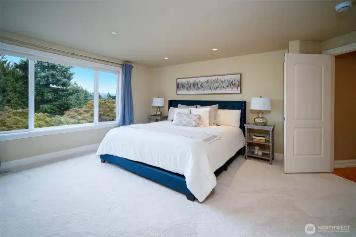 Expansive main-level primary suite features peek-a-boo lake views, luxe ensuite bath, and dual walk-in closets with custom cabinetry. Bathroom was completely remodeled with soaking tub, shower, new flooring and vanities.