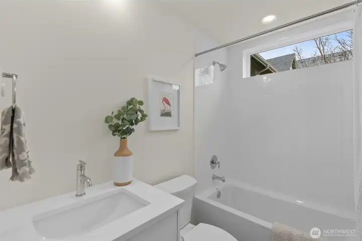 A bright bathroom retreat designed with stylish tilework and natural tones, balancing beauty with practicality. Photos are of model home with similar fixtures & finishes.
