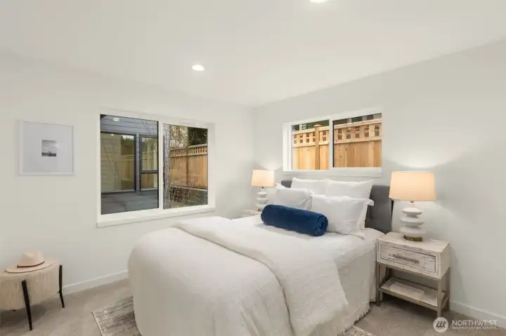 Secondary bedroom filled with natural light, offering flexibility for guests, children, or creative workspace. Photos are of model home with similar fixtures & finishes.