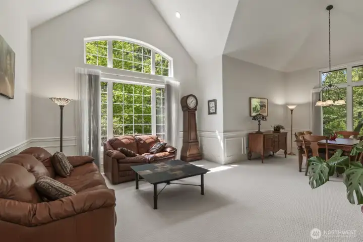 The open and spacious formal living and dining rooms boast tall vaulted ceilings and wainscoted walls.
