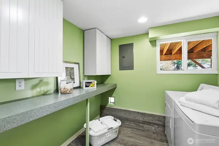 This laundry room with folding counter, cabinet storage, daylight and a deep sink make the task easier.