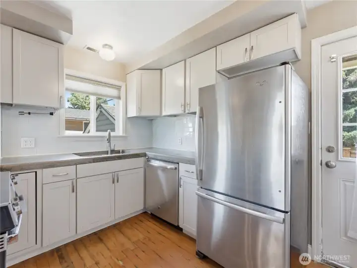 Kitchen with concrete counters, stainless appliances.
