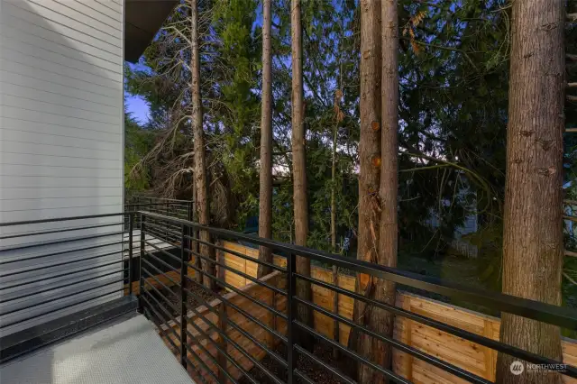 Step out onto this serene private deck surrounded by lush greenery, offering a peaceful retreat to enjoy morning or evening coffee.