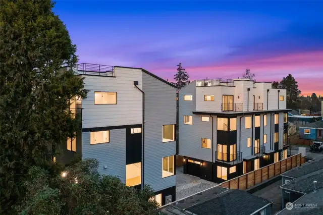 A stunning exterior view of modern multi-story homes against a vibrant dusk sky.