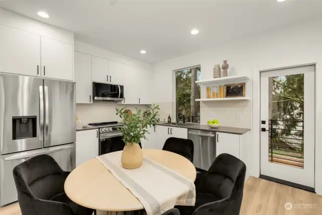 Cook culinary creations in this chic kitchen featuring stainless steel appliances, sleek cabinetry, and a seamless connection to the dining area and outdoor space.