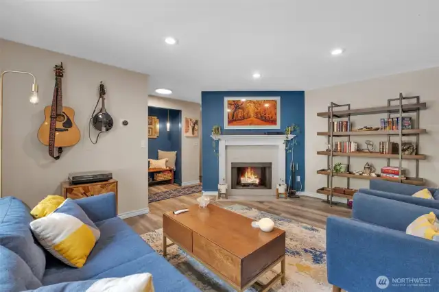 Living room with recessed light and woodburning fireplace.