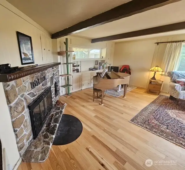 Huge fireplace with original cupboards for wood storage and the beams in the ceiling highlight this expansive living/dining room with the amazing view out to the ocean!