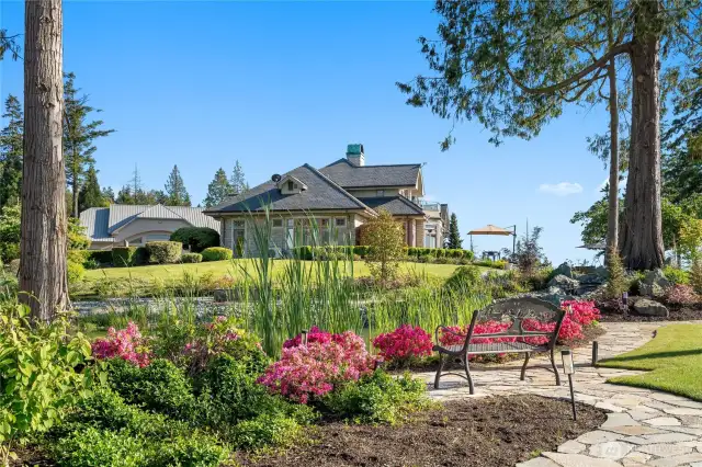 Mature trees and seasonal blooms  adorn the Rose garden and over 5 acres of land to the North. This beautiful luxury ,serenity, habitat pond with gentle terraced waterfall echoes with life in the evening.