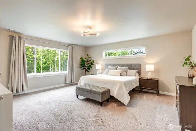 The spacious primary bedroom is filled with natural light