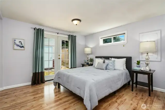 Primary bedroom with a walk-in closet, bathroom, and french doors to outside.