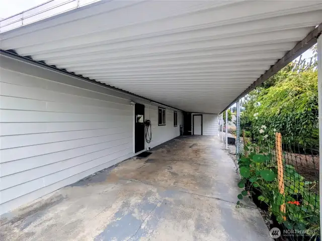 Long driveway. EV charger to the right of the carport entry door.