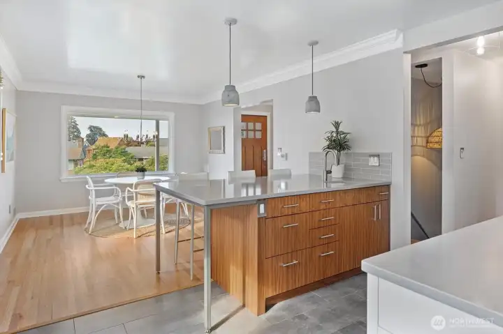 Open dining area off the recently updated kitchen. Large picture window frames a pleasant outlook over the landscaped front yard, neighborhood treetops, and view down the corridor to the Sound creating an inviting backdrop for meals and gatherings.