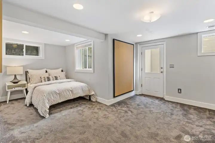 One of two lower-level bedrooms featuring great ceiling height, abundant natural light, and a separate entrance—ideal for guests, office, or multi-generational living.