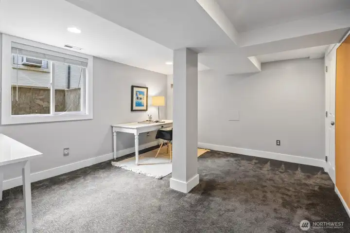 Bedroom number four, currently staged as an office, offers flexibility for work-from-home, guest use, or creative space—brightened by a large window for natural light and proper egress.