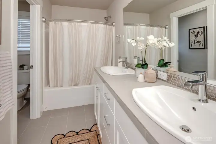 full bath with dual sinks on upper level