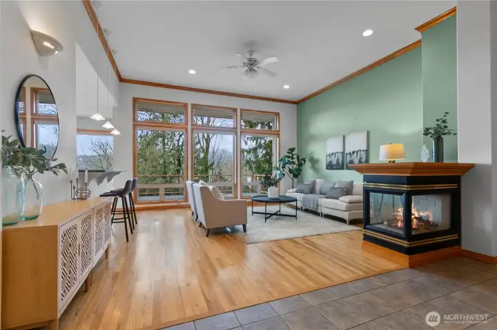 Living room with large windows, fireplace, and hardwood floors