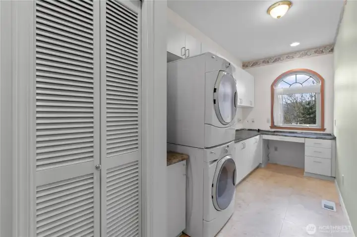 Laundry room with washer/dryer, cabinetry, and office nook.