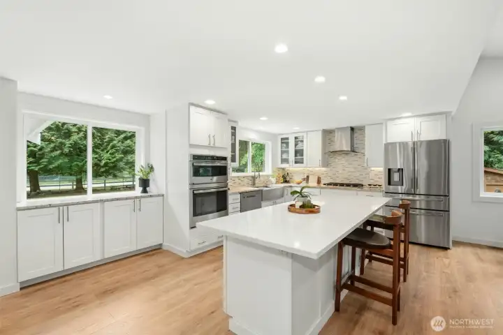 Large chef’s kitchen with sleek quartz slab countertops and stainless-steel appliances