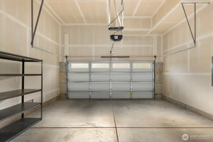 Two car garage with high ceilings for extra storage.