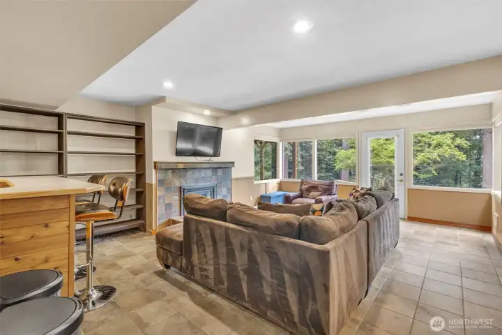 Living room w/ gas fireplace (lower floor). Door to patio & backyard.