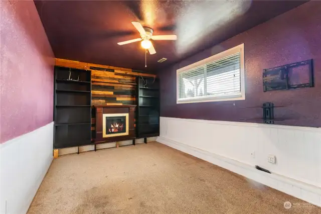 Fourth bedroom features built-ins, ceiling fan and electric fireplace.