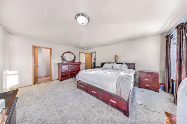 The primary bedroom hosts generous space, natural light in a relaxing atmosphere.