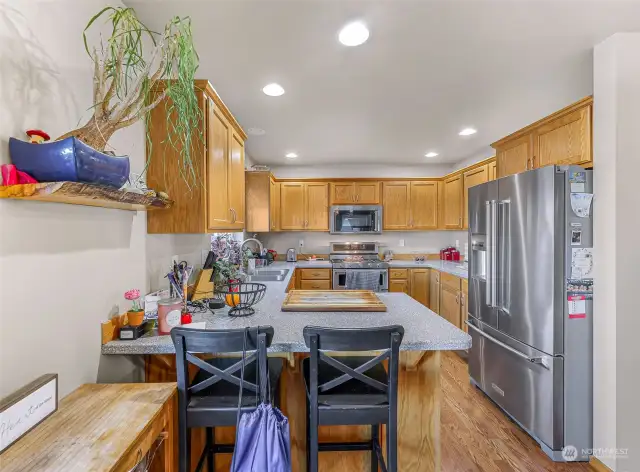 The kitchen, equipped with stainless steel appliances, offers ample storage and counter space.