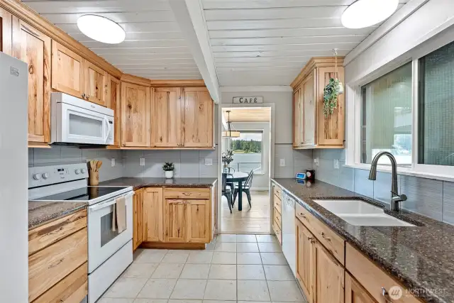 Cook with nature as your backdrop—this warm, well-appointed kitchen pairs natural wood cabinetry with peaceful lake views, offering everyday function and timeless charm. For those dreaming of an open-concept flow, the owners once considered removing the dividing wall to create a more connected space between the kitchen and main living area—an opportunity still full of potential.