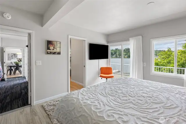 The main-floor primary bedroom is a private haven with direct deck access and a massive walk-in closet—offering potential to convert into a sitting room, guest suite, or even a second kitchen for multi-gen living.