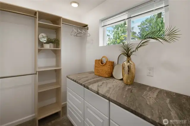 Enjoy the convenience and luxury of this walk in closet with built in shelving and stunning quartz dresser.