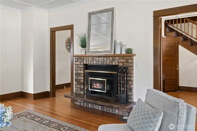 The wood-burning fireplace insert evokes classic warmth and historic character, while offering practical backup heat to complement the new HVAC system during colder months.
