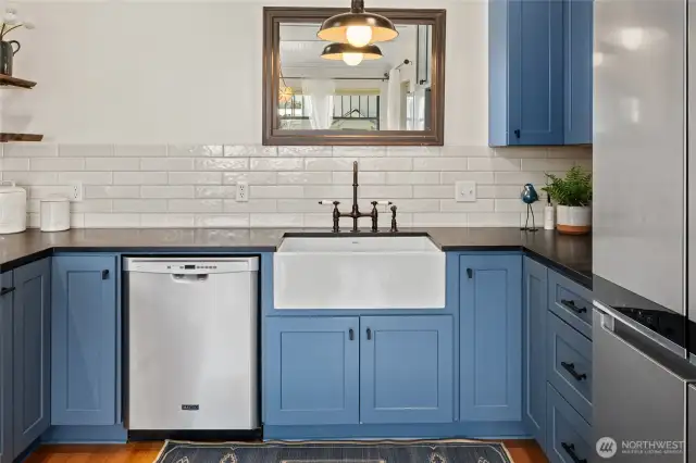 The farmhouse sink, complemented by Mason Hill Collection fixtures, brings both charm and high-end craftsmanship to the kitchen.