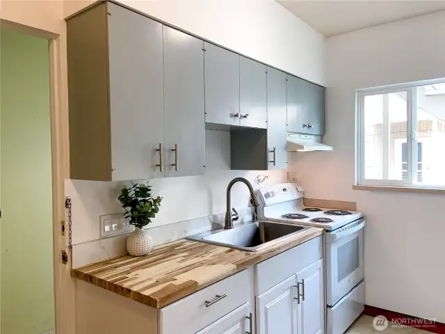 The kitchen is cozy, fresh, and clean.  That's a new stove and counter top.