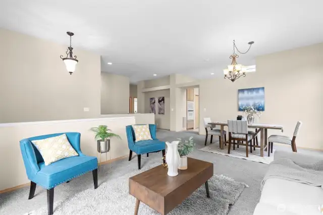 A spacious living area with large windows, offering natural light and a comfortable space for family and guests.