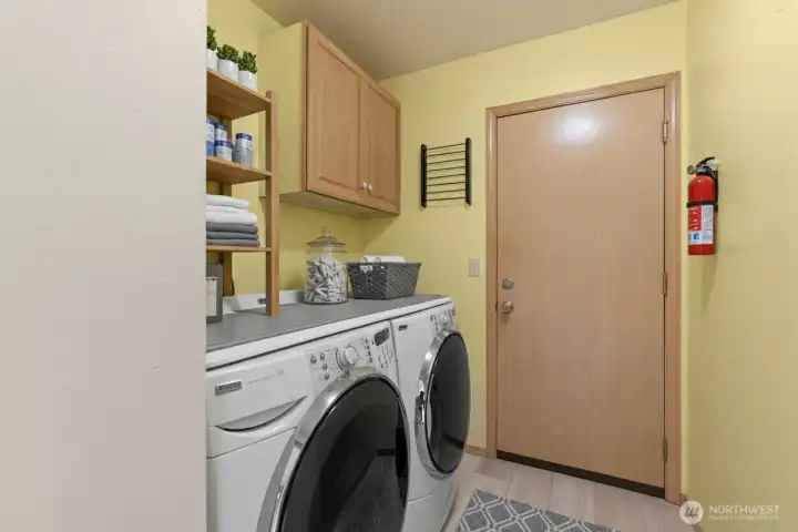 Spacious laundry room with cabinetry and folding counter. (Virtually Staged)