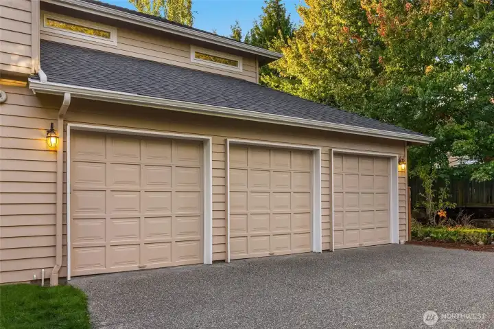 Roomy 3-car garage with EV charger and ceiling storage racks.