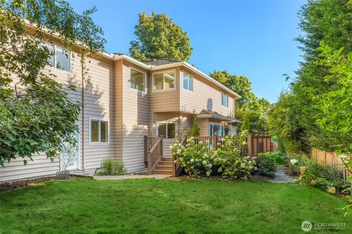 Private backyard surrounded by mature landscape and lush greenery.