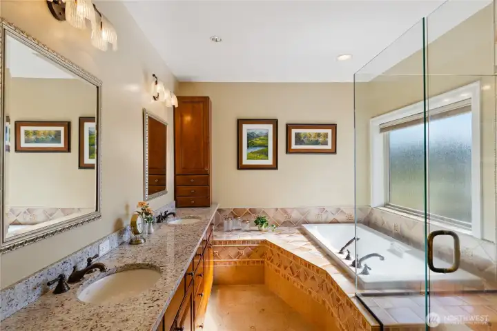 Spacious primary bathroom with two primary walk-in closets