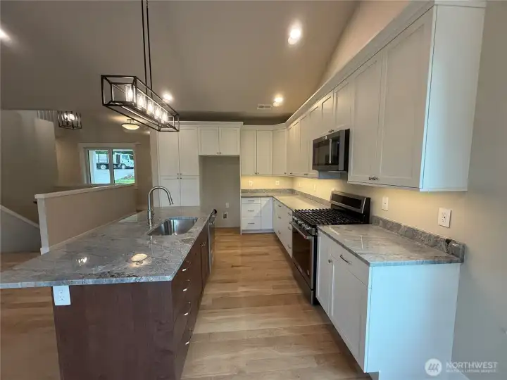 Open concept, two tone cabinetry, granite counters, Cabinets finished with crown molding and under mount lighting