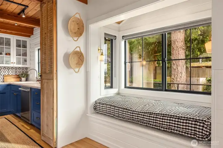 Comfortable window seat between the dining room and kitchen is the perfect place to read a cookbook and plan the evening's meal.