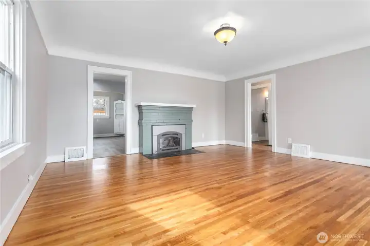Living room features gas fireplace and refinished wood floors