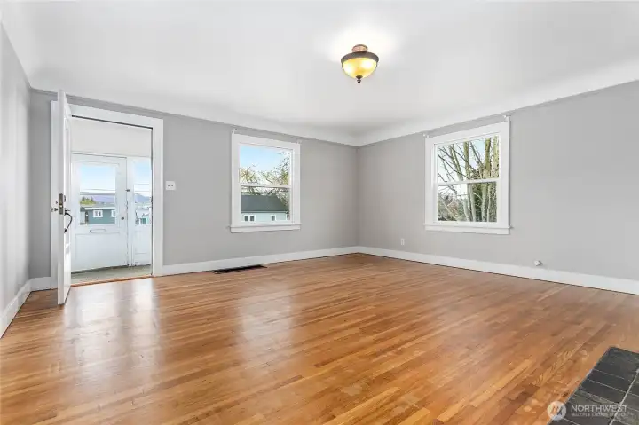 Living room features gas fireplace and refinished wood floors