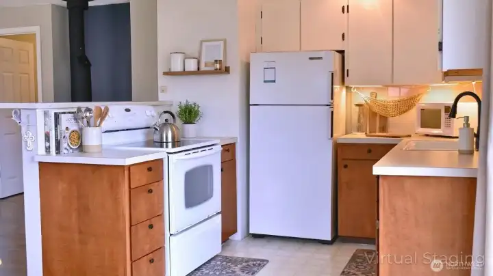 Bright and efficient, the kitchen features clean white cabinetry, warm wood accents, and a practical layout that flows easily into the main living space.