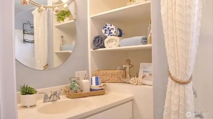 Bright vanity area with open built-in shelving, a clean countertop, and simple coastal touches that add both function and charm.