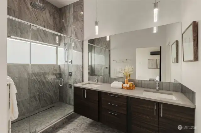 Floating vanity with dual sinks, designer pendants, under vanity lighting and plenty of storage.