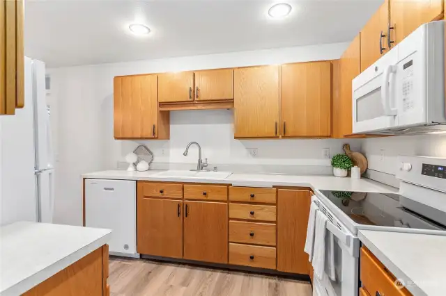 Light and bright kitchen with NEW appliances & lighting fixtures. New white quartz countertops and sink are being installed prior to closing.