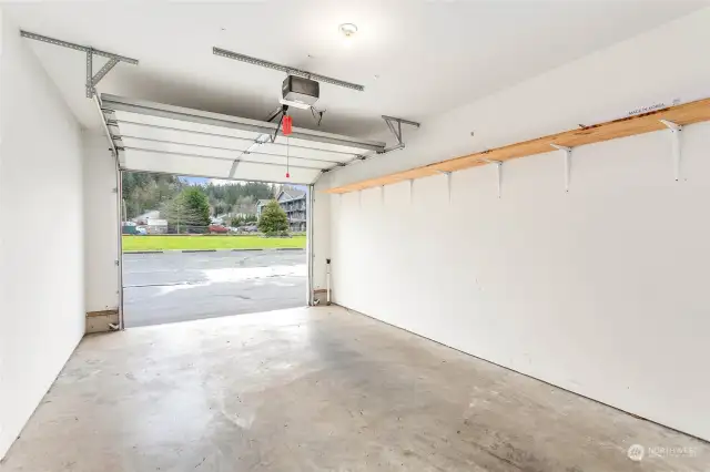 The interior of the garage. There is extra shelving on one side and the back for storage.